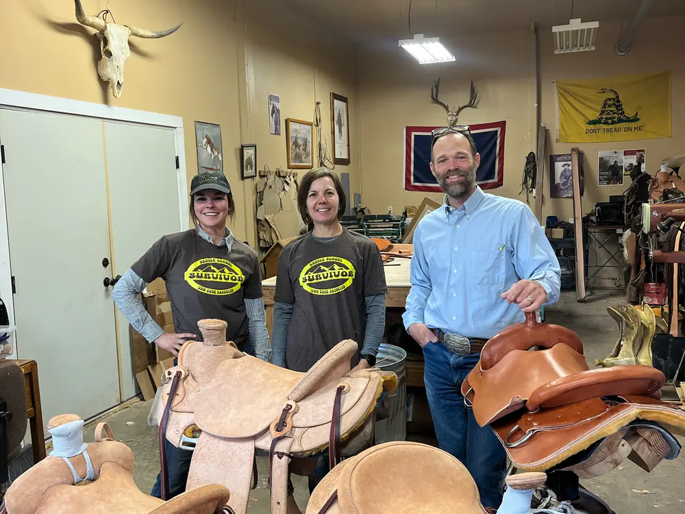 Two saddlery students in the Sheridan shop with their finished saddle trees and skirts
